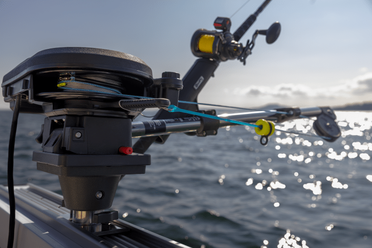 Scotty electric downrigger mounted on a track pedestal mount—together with fishing rod and reel shown in the included downrigger rod holder.